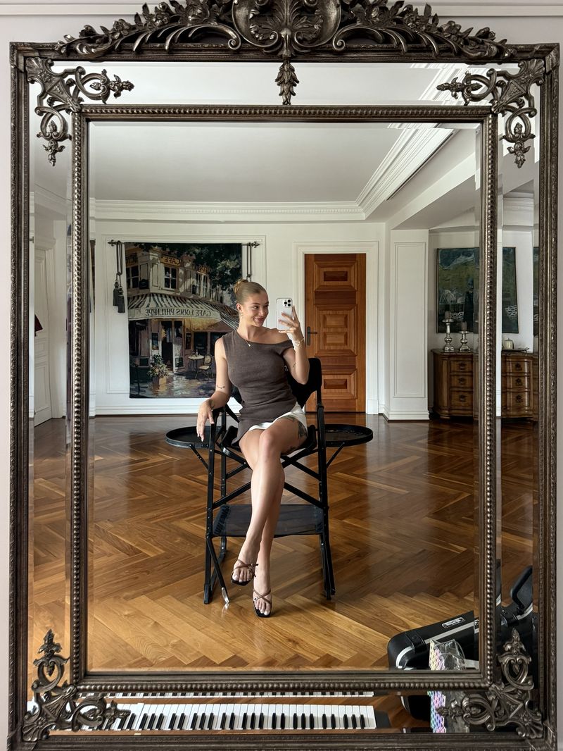 Abbi seated in her styling chair, photographed in an ornate mirror